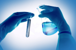 Chem-test-tube Gloved hands holding a test tube and a beaker with liquid, representing water quality testing